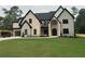 Stunning two-story home featuring stone and brick, a black roof, and black-trimmed windows at 2728 Talley Ln, Buford, GA 30519