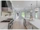 Gourmet kitchen featuring a large range, custom vent hood, and views of the backyard at 2728 Talley Ln, Buford, GA 30519