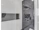 Elegant shower space with marble tile, rainfall shower head, and geometric pattern shelving at 2728 Talley Ln, Buford, GA 30519