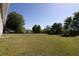 An expansive backyard featuring a large grassy area, mature trees, and a wooden fence at 7105 Boulder Pass, Union City, GA 30291