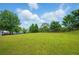 A sprawling backyard featuring well-maintained grass, mature trees, a blue sky, and a classic wooden fence at 7105 Boulder Pass, Union City, GA 30291