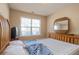 A cozy bedroom with a wood frame bed, dresser and mirror complemented by natural light from the window at 7105 Boulder Pass, Union City, GA 30291