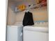 A well-lit laundry room featuring a washer, dryer, wire shelving, and ample storage space for cleaning supplies at 7105 Boulder Pass, Union City, GA 30291