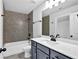 Bathroom with a tiled shower, white vanity with gray cabinets, and a modern black faucet at 7474 Waterview Cv, Douglasville, GA 30135