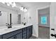 Bathroom featuring double sink vanity with modern fixtures, an expansive mirror, and a private toilet room at 7474 Waterview Cv, Douglasville, GA 30135