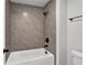 Tiled shower-tub combination featuring a modern shower head and black fixtures at 7474 Waterview Cv, Douglasville, GA 30135