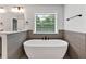 Modern bathroom featuring a soaking tub, natural light, and stylish fixtures at 7474 Waterview Cv, Douglasville, GA 30135