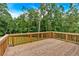 Spacious wood deck featuring a stained wood rail overlooking mature trees at 7474 Waterview Cv, Douglasville, GA 30135