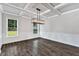 Bright dining room featuring hardwood floors, wainscoting, and modern lighting at 7474 Waterview Cv, Douglasville, GA 30135