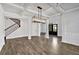 Open dining room featuring hardwood floors, wainscoting, coffered ceilings, and modern lighting at 7474 Waterview Cv, Douglasville, GA 30135
