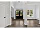 A bright open foyer with a dark front door and hardwood floors at 7474 Waterview Cv, Douglasville, GA 30135