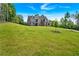 A well-manicured lawn leads up to a new construction house under a bright blue sky at 7474 Waterview Cv, Douglasville, GA 30135