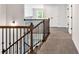 Second-floor hallway features carpet and decorative iron railing overlooking the stairs at 7474 Waterview Cv, Douglasville, GA 30135