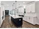 Modern kitchen featuring an island, white cabinetry, stainless appliances, and access to living room at 7474 Waterview Cv, Douglasville, GA 30135