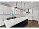 Beautiful open kitchen featuring an island, white cabinetry, stainless appliances, and pendant lights at 7474 Waterview Cv, Douglasville, GA 30135