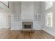 Bright, open living room featuring a stone fireplace, built-in shelves, and hardwood floors at 1209 Fenmore Hall Dr, Powder Springs, GA 30127