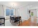 Bright dining room featuring hardwood floors, modern chandelier, and a large window with sheer white curtains at 1765 Stoney Creek Se Dr, Atlanta, GA 30316
