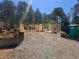A new home construction site shows the framing of a house with gravel and trees in the background on a sunny day at 190 Harville Rd, Covington, GA 30016