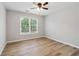 This bedroom features wood floors, a ceiling fan, and a window letting in natural light at 2620 Bent Creek Dr, Cumming, GA 30041