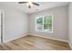Bright bedroom with wood-look flooring and a large window overlooking trees at 2620 Bent Creek Dr, Cumming, GA 30041