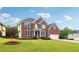 Charming brick house on a sunny lawn with a two-car garage and blue shutters at 2620 Bent Creek Dr, Cumming, GA 30041