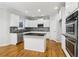 Bright kitchen features white cabinets, black countertops and stainless-steel appliances at 2620 Bent Creek Dr, Cumming, GA 30041