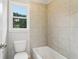 Bright bathroom features a soaking tub with tile surround and a window view at 2620 Bent Creek Dr, Cumming, GA 30041
