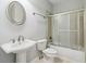 A full bathroom features a pedestal sink, tile flooring, and a shower with sliding doors at 2620 Bent Creek Dr, Cumming, GA 30041