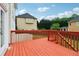 Spacious wooden deck with red railing, offering views of the yard and surrounding homes at 2620 Bent Creek Dr, Cumming, GA 30041