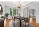 Formal dining room featuring hardwood floors, chandelier, and large window overlooking front yard at 2620 Bent Creek Dr, Cumming, GA 30041