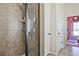 Updated bathroom featuring a tile shower with glass door and a view into a pink bedroom at 3877 Valley Bluff Ln, Snellville, GA 30039