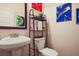 Updated bathroom featuring a toilet, sink, and open shelving with modern decor and colorful accents at 3877 Valley Bluff Ln, Snellville, GA 30039