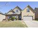 Charming two-story home with a well-manicured lawn and a two-car garage on a sunny day at 3877 Valley Bluff Ln, Snellville, GA 30039