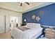 This primary bedroom features a blue accent wall, tray ceiling, and ensuite bathroom at 3877 Valley Bluff Ln, Snellville, GA 30039