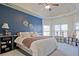 This is a spacious primary bedroom with a tray ceiling, blue accent wall, and dual windows at 3877 Valley Bluff Ln, Snellville, GA 30039