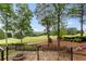 Beautiful backyard with golf course view, stone patio, wrought iron fencing, and mature trees at 5106 Davis Love Dr, Cumming, GA 30041