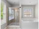 Bathroom featuring a glass-enclosed shower and a soaking tub at 5106 Davis Love Dr, Cumming, GA 30041