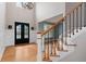Bright foyer featuring double-doors, wainscoting details, hardwood floors, and a staircase with iron spindles at 5106 Davis Love Dr, Cumming, GA 30041