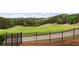 Scenic golf course view through wrought iron fence surrounded by mature trees and lush green landscaping at 5106 Davis Love Dr, Cumming, GA 30041