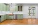 Bright kitchen with stainless steel appliances, sage green cabinets, and access to the back porch at 5106 Davis Love Dr, Cumming, GA 30041