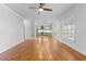 Open-concept living space with hardwood floors and view to a kitchen with sage green cabinets at 5106 Davis Love Dr, Cumming, GA 30041