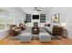 Bright living room featuring a fireplace, built-in shelving, modern furniture, and large windows for natural lighting at 5106 Davis Love Dr, Cumming, GA 30041