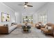 Cozy living room featuring modern furniture, including two sitting chairs, a couch, and a view to the kitchen at 5106 Davis Love Dr, Cumming, GA 30041