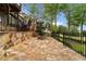 Enjoy outdoor entertaining on this expansive stone patio with a fire pit and wrought iron fencing at 5106 Davis Love Dr, Cumming, GA 30041