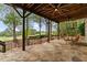 Relax outdoors under a ceiling fan on this stone patio featuring a hanging daybed and golf course views at 5106 Davis Love Dr, Cumming, GA 30041