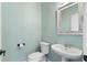 Light blue powder room with pedestal sink, toilet, and a decorative mirror at 5106 Davis Love Dr, Cumming, GA 30041