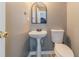 Clean half bathroom with a pedestal sink, toilet, mirror, and neutral wall color at 1542 Armende Cir, Dacula, GA 30019