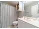 Bathroom features white vanity with a framed mirror, storage cabinet, and a neutral shower curtain at 1542 Armende Cir, Dacula, GA 30019