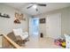 Neutral bedroom features a ceiling fan, wood decoration with a name, white chair and plush carpet at 1542 Armende Cir, Dacula, GA 30019