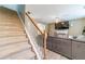 Staircase leading to the living room featuring a large gray sectional couch, ceiling fan, and fireplace at 1542 Armende Cir, Dacula, GA 30019